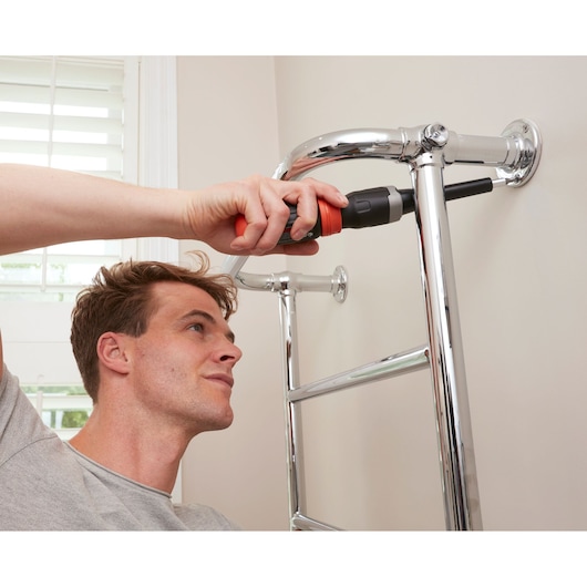 Photo of BLACKDECKER BCF601C cordless screwdriver used to install chrome towel rack on wall indoors.