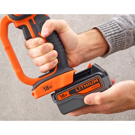 Close-up of hands attaching an 18V lithium 4.0AH battery to a BLACK+DECKER power tool with orange and black accents.