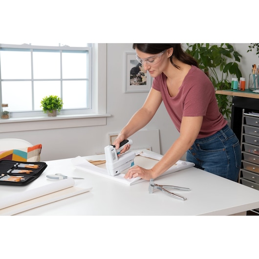 BLACKDECKER BCN115 stapler used for crafting on a workspace table indoors.
