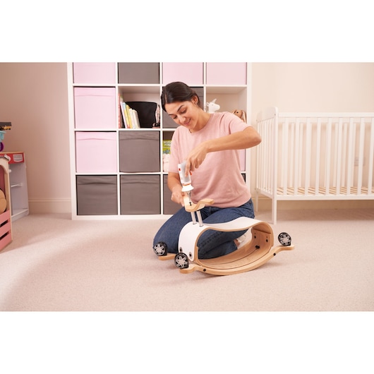BLACKDECKER BCRTA01 cordless screwdriver used to assemble a wooden ride-on toy in a nursery setting.