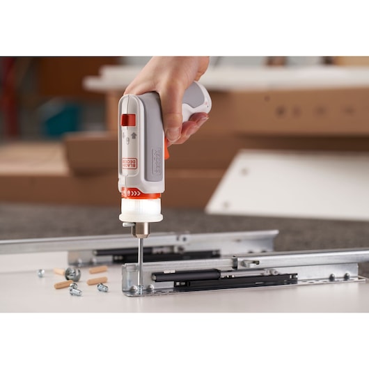 BLACKDECKER BCRTA01 cordless screwdriver in use for furniture assembly, close-up on fastener installation.