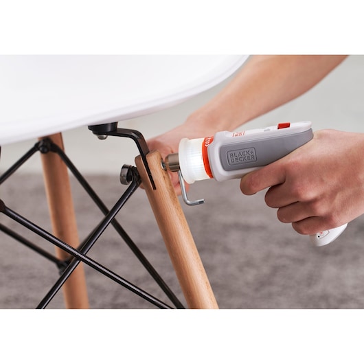 Photo of BLACK+DECKER BCRTA01 cordless screwdriver tightening a bolt on a wooden chair leg.