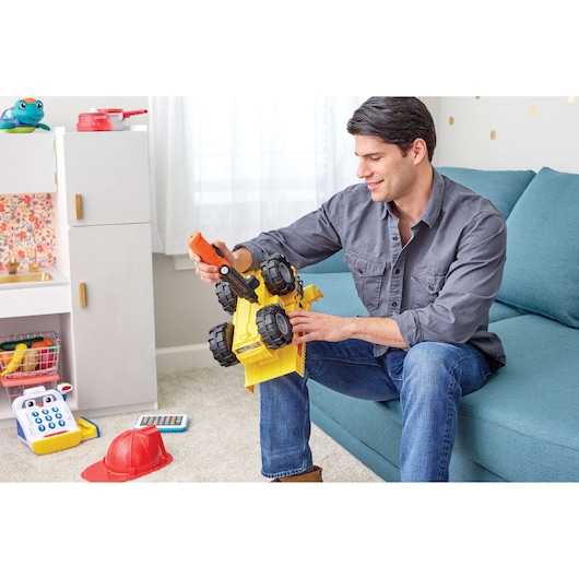 BLACKDECKER BDCSFL20C cordless screwdriver used on yellow toy truck in living room setting.