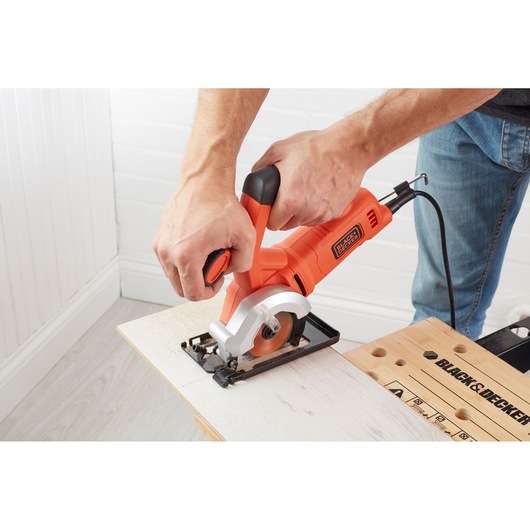 BLACK+DECKER BES510K mini circular saw cutting wood, close-up action shot.
