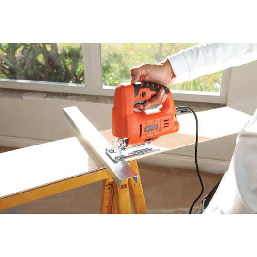 Photo of BLACKDECKER BES601 jigsaw cutting wood, handheld in home workshop setting.