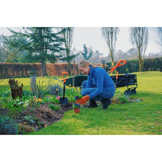 BLACKDECKER BETL1820L garden tool photography with cart, shovel, and gloves in use during outdoor planting.