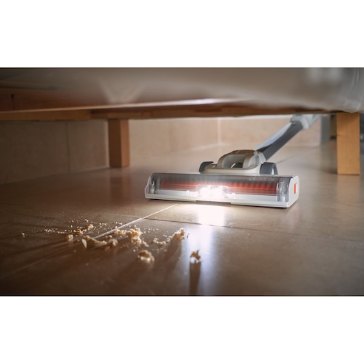BLACKDECKER BHFEA515J vacuum with LED light cleaning crumbs on tile floor under furniture.