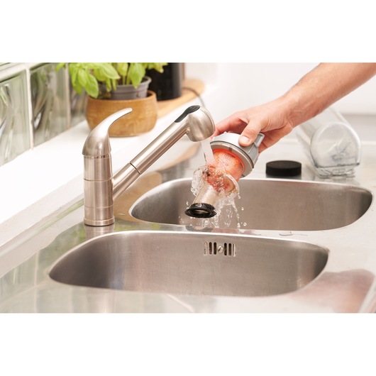 BLACKDECKER BHFEA515J vacuum filter being cleaned under a kitchen faucet, close-up view.