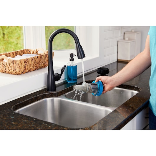 BLACKDECKER BHFEB520D1 vacuum filter being washed under kitchen faucet near sink.