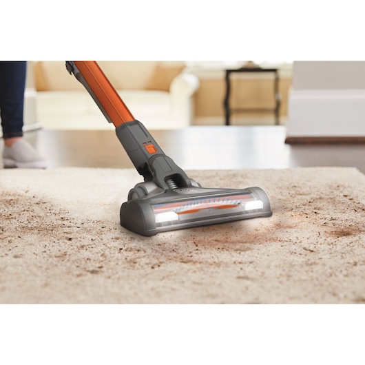 BLACKDECKER BHFEV182B cordless vacuum cleaner head with LED lights cleaning dirty carpet in living room.