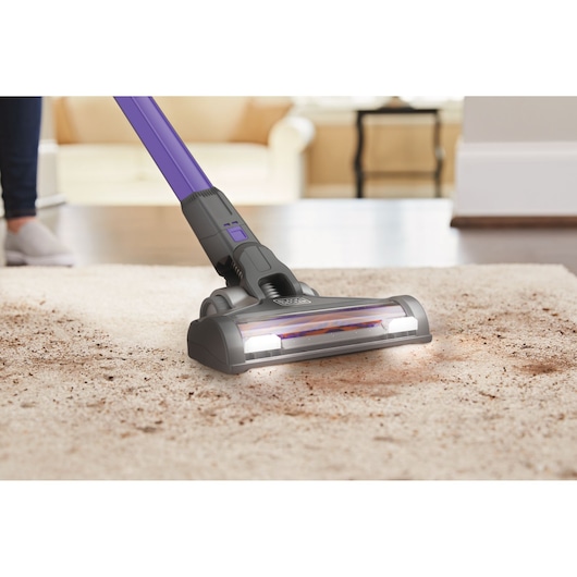 BLACKDECKER BHFEV362DP stick vacuum cleaning dirty carpet, close-up view with visible LED lights.
