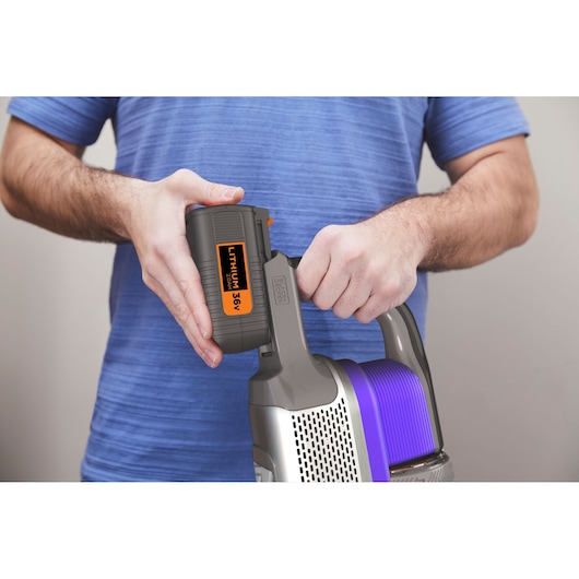 BLACKDECKER BHFEV362DP cordless vacuum with 36V lithium battery being inserted, close-up of handle and battery.
