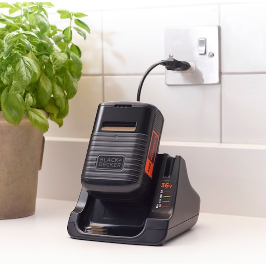 BLACKDECKER 36V battery charger BHFEV36B2D on kitchen counter, plugged in, side angle.