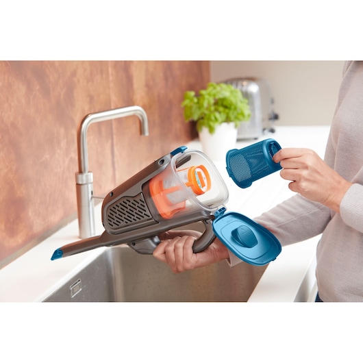 Photo of BLACKDECKER BHHV320B handheld vacuum with filter removed, shown over a kitchen sink.