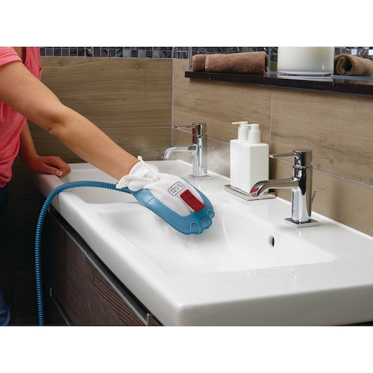 BLACKDECKER BHSM1610DSM steam cleaning glove being used to clean a white bathroom sink.