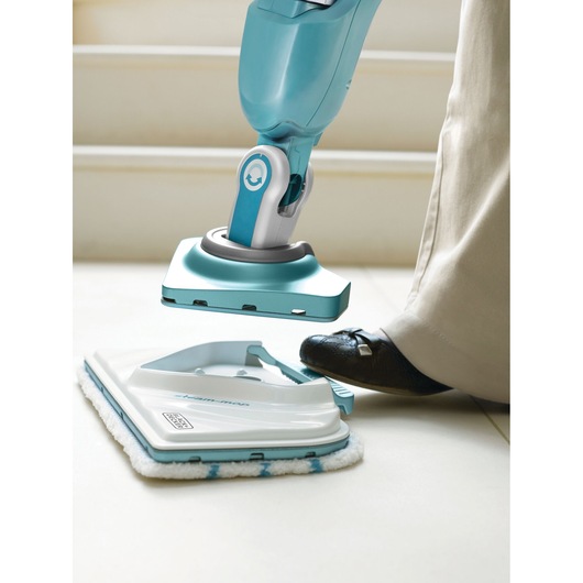 BLACKDECKER BHSM166DSM steam mop head being detached using foot pedal, close-up indoor view.