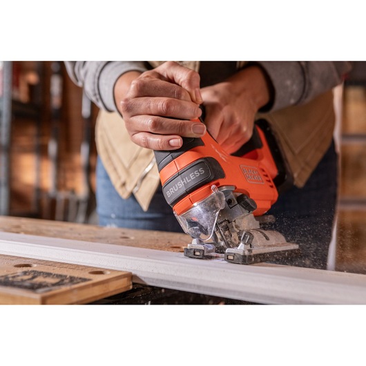 Photo of BLACKDECKER BLCJS78N brushless jigsaw cutting wood, close-up view of hand holding tool.