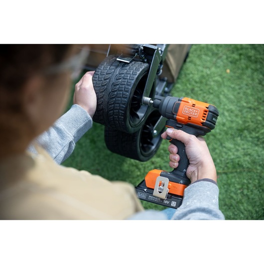 Photo of BLACKDECKER BLIM78N cordless impact wrench used to tighten bolts on a cart wheel outdoors.