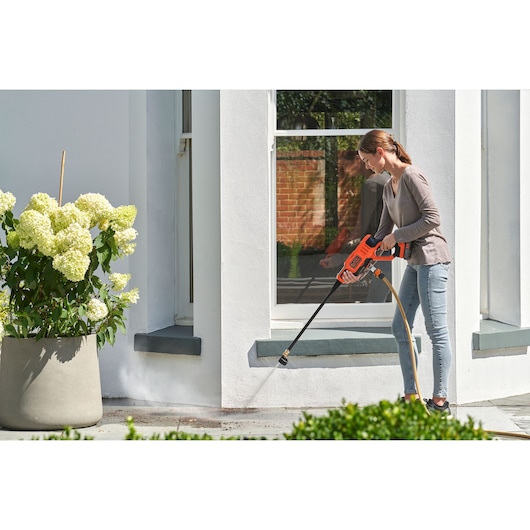 Photo of BLACKDECKER BZOQDW1 pressure washer in use cleaning outdoor patio near white house.