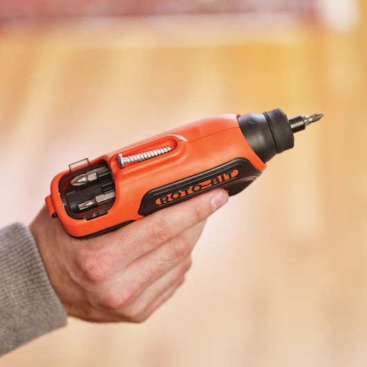 BLACKDECKER CS36BSC compact orange cordless screwdriver with bit storage, held in hand.