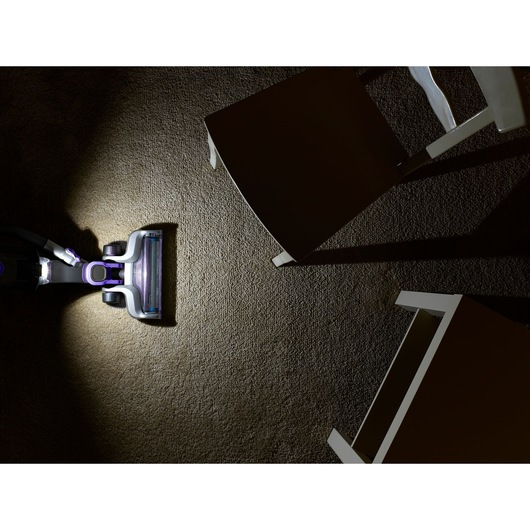 BLACKDECKER CUA525BHP vacuum cleaner head on carpet, overhead angle, cleaning near white chairs