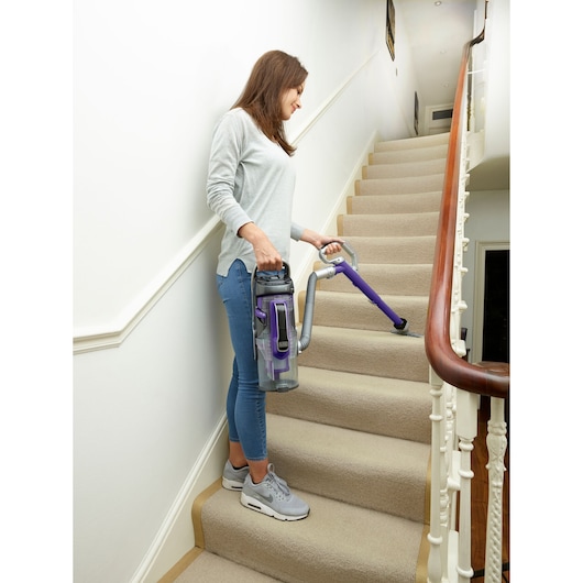 BLACKDECKER CUA525BHP vacuum cleaner used on carpeted stairs with purple and grey design.