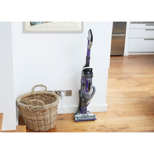 BLACKDECKER CUA525BHP upright vacuum cleaner in purple and grey, standing on wooden floor in a home setting.