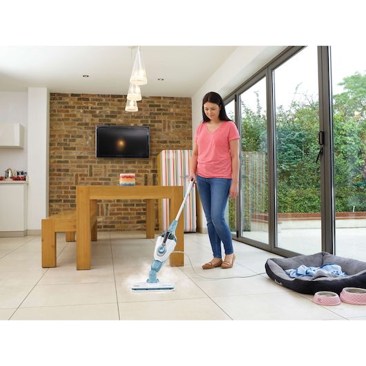 BLACKDECKER FSMH1321 steam mop cleaning tile floor in modern kitchen with dining table.