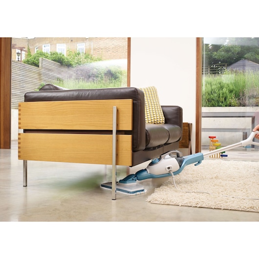 BLACKDECKER FSMH1321 steam mop cleaning under sofa in modern living room.