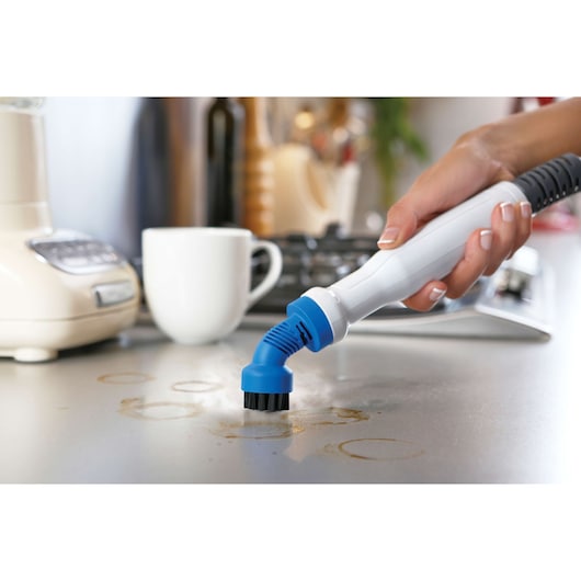 BLACKDECKER FSMH1321 steam cleaner cleaning kitchen countertop with blue brush attachment.