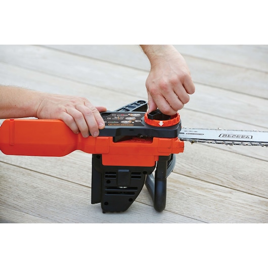 Photo of BLACKDECKER GKC3630L20 chainsaw being adjusted by hand, focusing on the tool-free chain tensioning system.