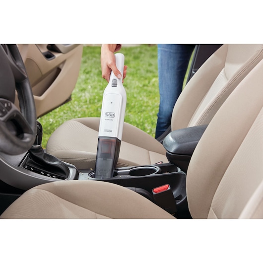 BLACKDECKER HLVC315B11 handheld vacuum cleaner being used to clean a car interior.