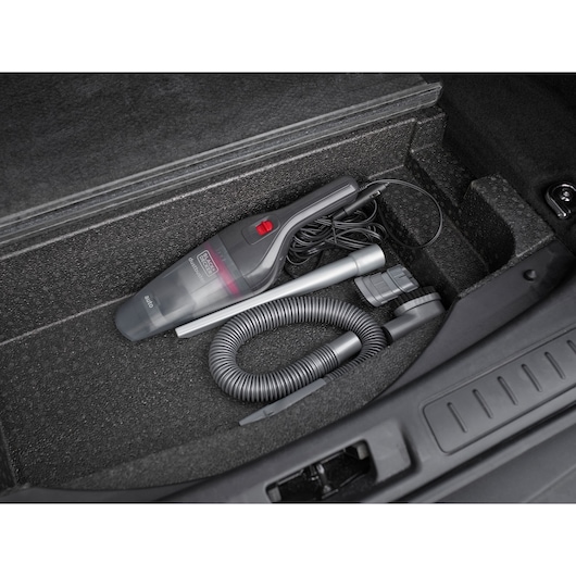 BLACKDECKER NVB12AVA handheld vacuum cleaner with accessories in a car trunk.
