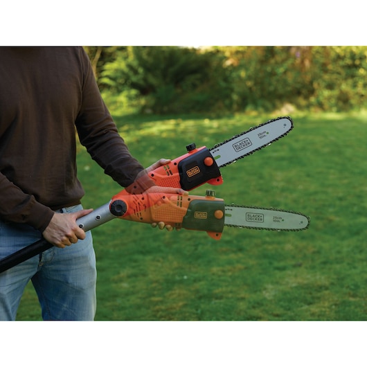 BLACK+DECKER PS7525 pole saw in use cutting outdoors, showing adjustable head feature, 25cm chain bar visible.