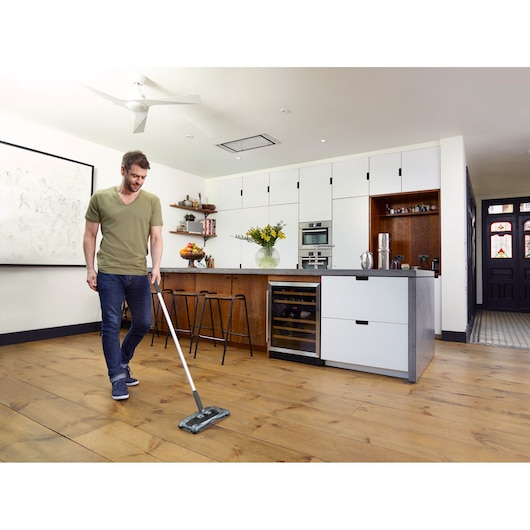 BLACKDECKER PSA215B cordless floor mop used on wooden kitchen flooring.