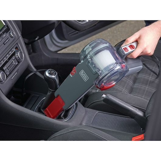 BLACK+DECKER PV1200AV handheld car vacuum cleaner with pivoting nozzle cleaning around gear shift inside car.